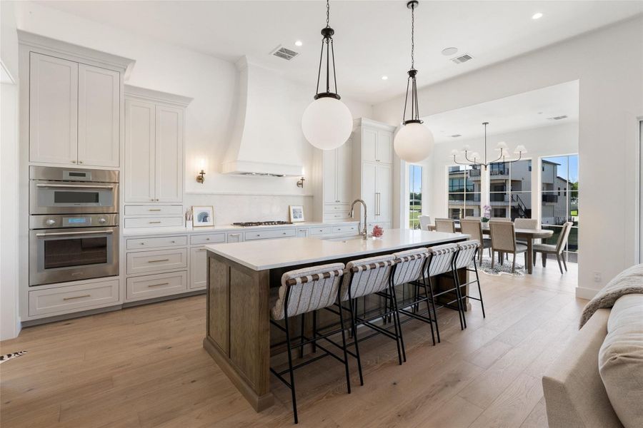 A well-appointed kitchen features a large island with seating, a gas range, and built-in appliances. A well-appointed kitchen features a large island with seating, a gas range, and built-in appliances.