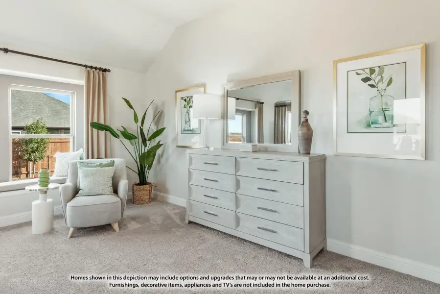 Bedroom sitting area with vaulted ceiling, gray dresser with mirror, accent chair, and carpet flooring