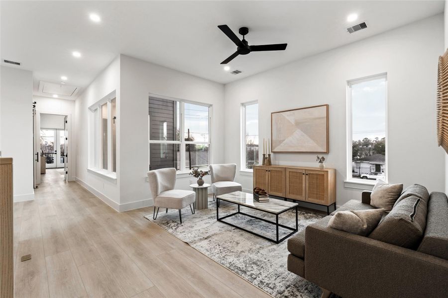 Natural light pours in from multiple exposures, creating a serene secondary living space designed for slow mornings or quiet evenings.