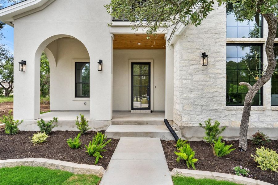 A graceful arched entry welcomes all to this meticulously crafted residence, boasting a smooth stucco finish.