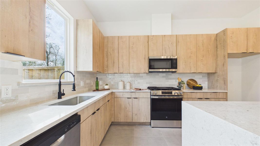 Arcadia Yellow Walnut cabinetry with stunning quartz countertops, a waterfall island beautifully ties this room together!