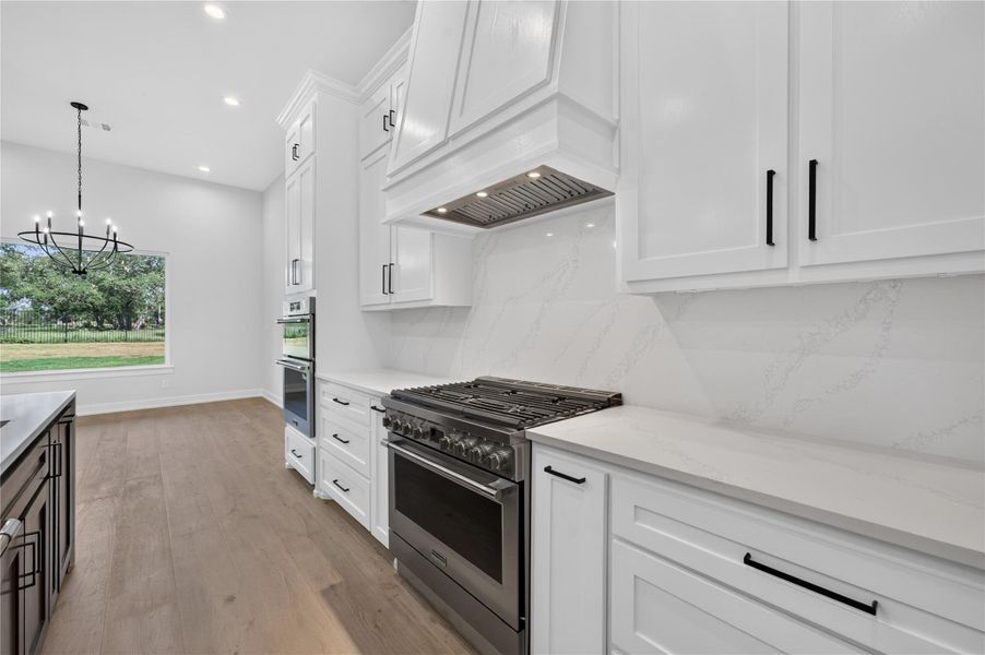 Hardwood floors and quartz stone surfaces anchor this modern culinary space.