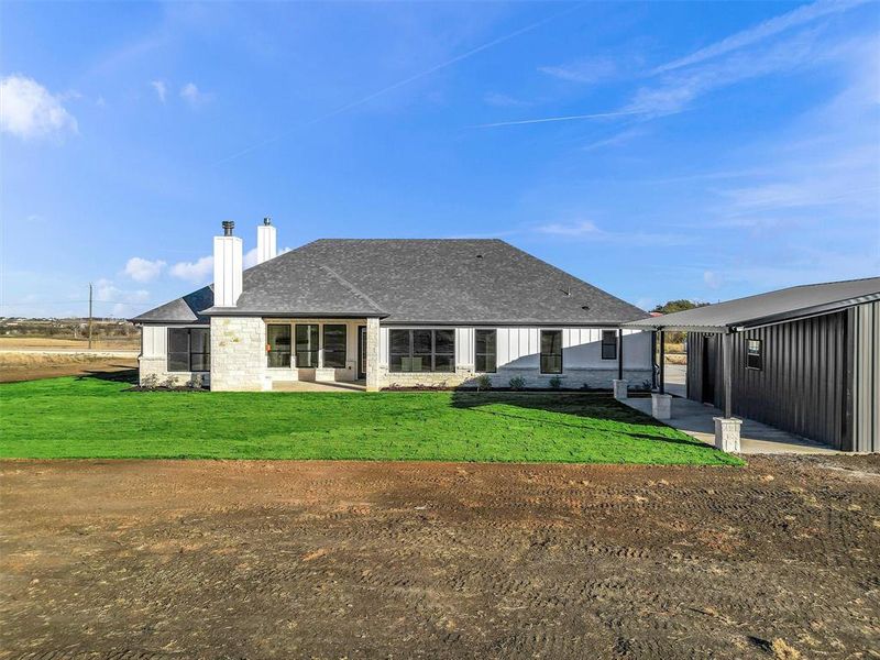 Rear view of property featuring a yard and a patio area