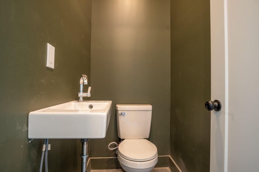 Half bathroom with toilet and baseboards