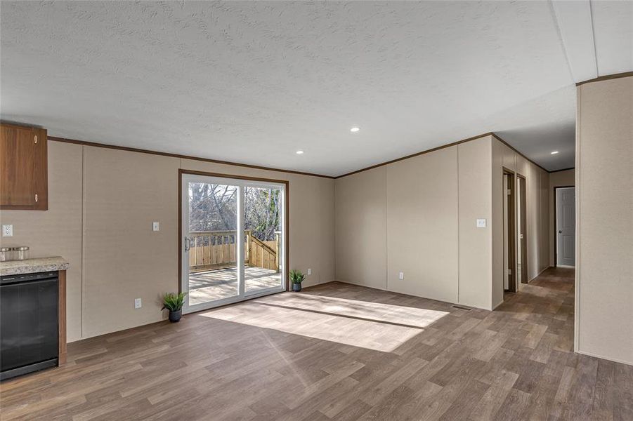 Unfurnished living room featuring ornamental molding and light wood-type flooring