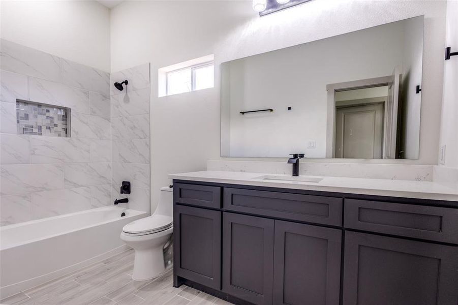 Full bathroom with vanity, toilet, and tiled shower / bath