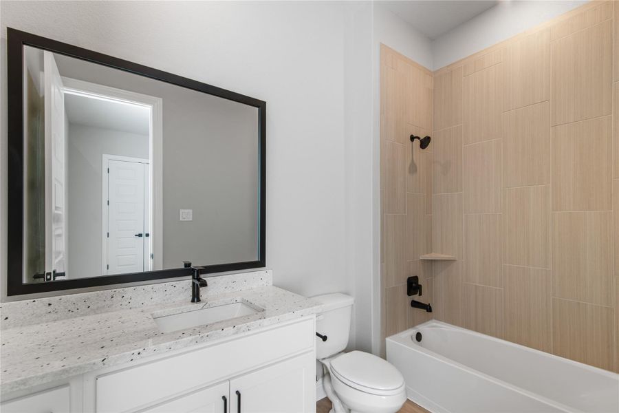 bedroom with its on bathroom with quartz counter tops.