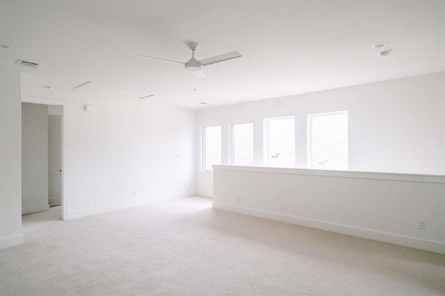 Spare room with light colored carpet and ceiling fan