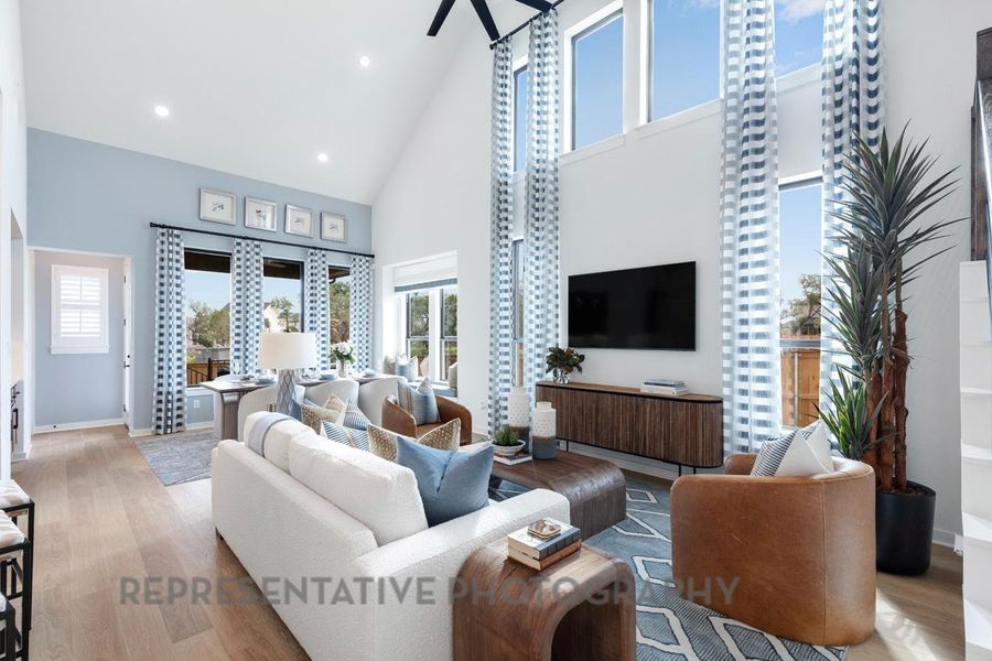 Living area featuring wood finished floors, high vaulted ceiling, and recessed lighting Living area featuring wood finished floors, high vaulted ceiling, and recessed lighting