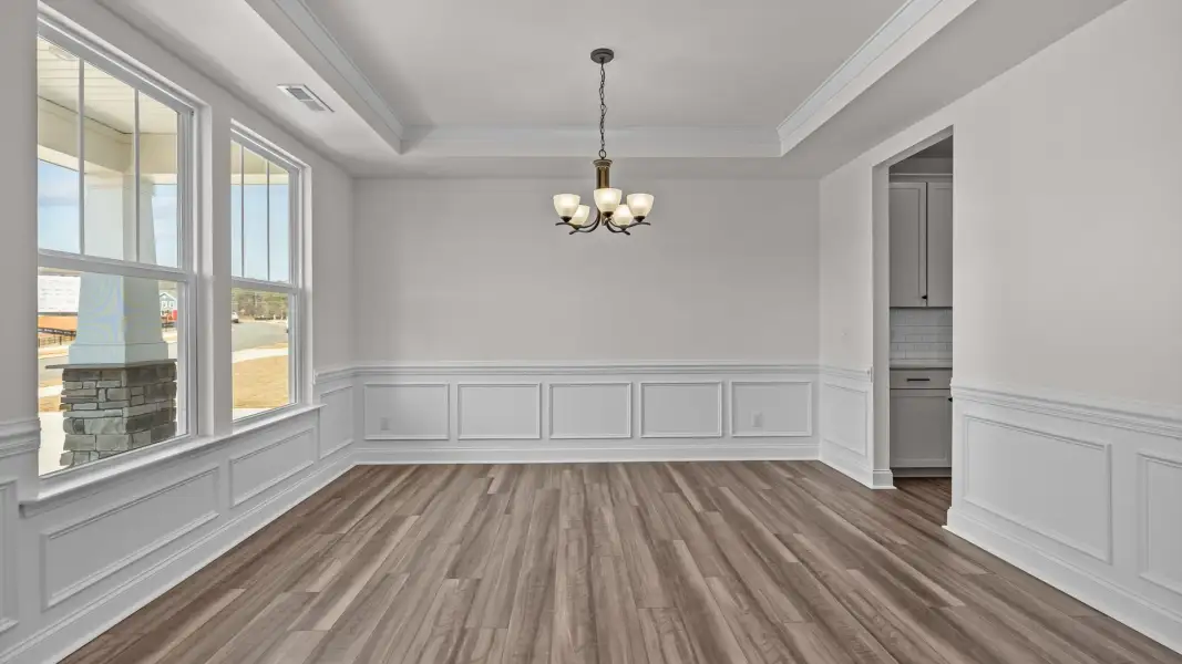Elegant dining with pass-through butler's pantry, elevated tray ceiling, and premium trim, in the Norris Design by DRB Homes Elegant dining with pass-through butler's pantry, elevated tray ceiling, and premium trim, in the Norris Design by DRB Homes