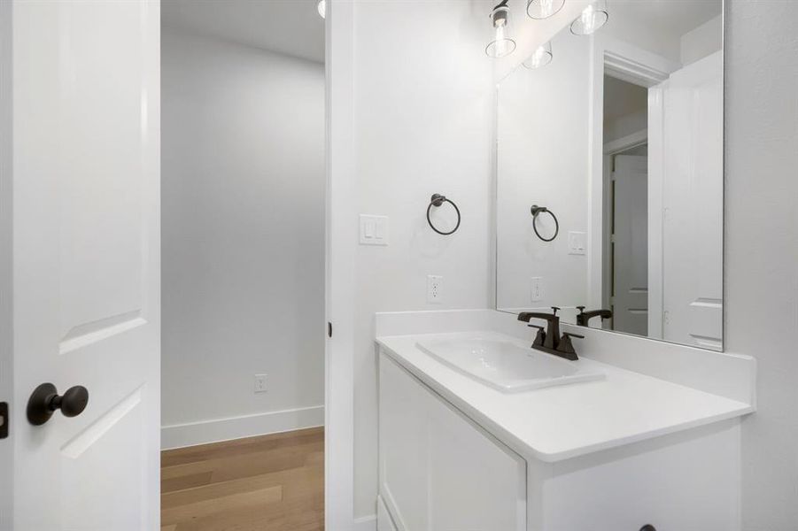 Bathroom vanity with integrated sink, white countertop, dark bronze faucet, and rectangular mirror Bathroom vanity with integrated sink, white countertop, dark bronze faucet, and rectangular mirror