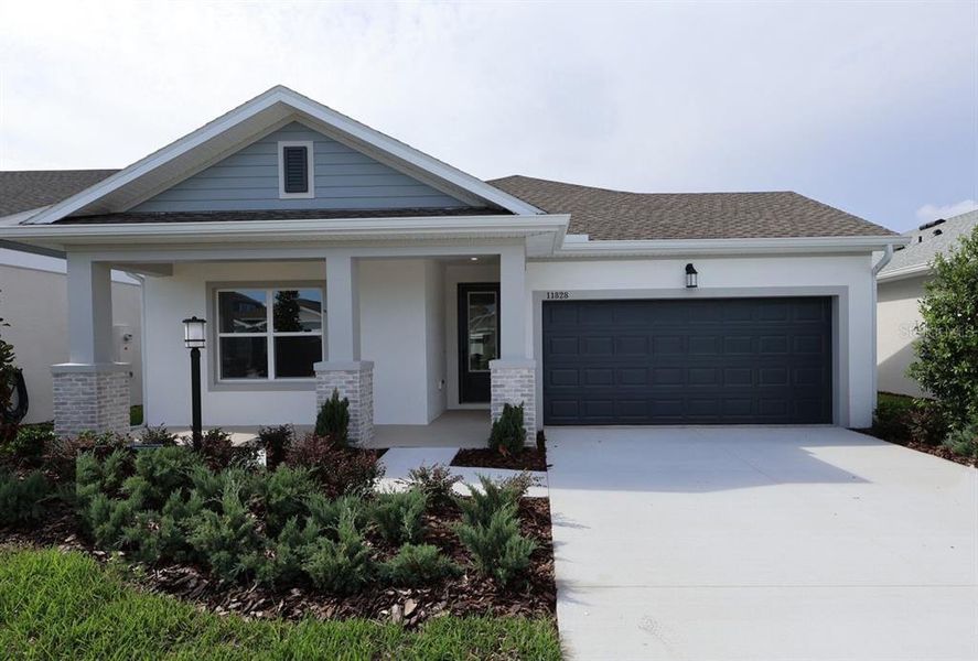 Front exterior of a new home in The Peninsula at Rhodine Lake, Riverview, FL, highlighting curb appeal (Image 1).