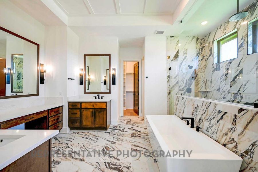 Bathroom with a freestanding tub, a marble finish shower, vanity, a walk in closet, and light marble finish floors Bathroom with a freestanding tub, a marble finish shower, vanity, a walk in closet, and light marble finish floors