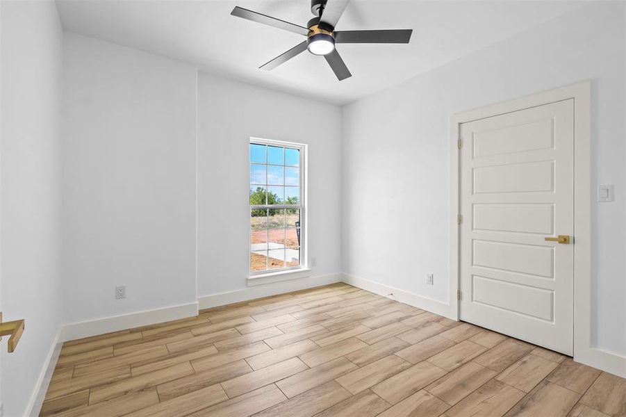 Spare room featuring wood finish floors and a ceiling fan