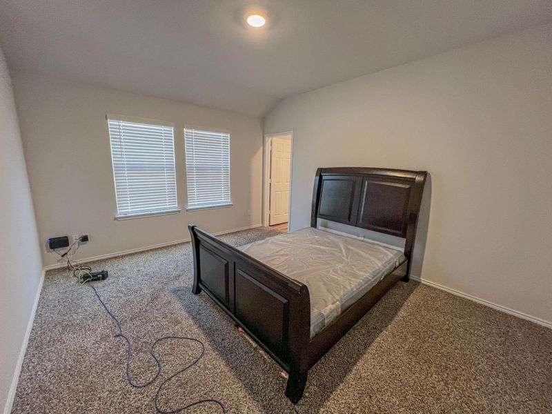 Bedroom featuring lofted ceiling and carpet flooring