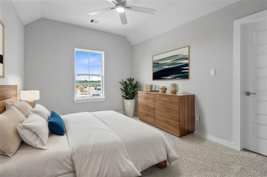 Secondary bedroom features plush carpet, custom paint, ceiling fan, large window with privacy blinds, and private access to a secondary bathroom.