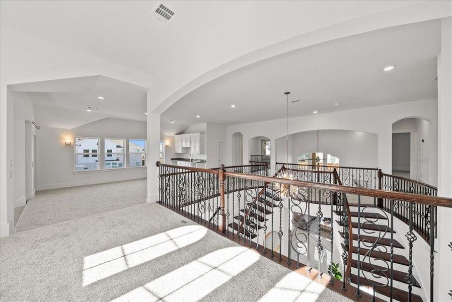 Hallway featuring carpet flooring, recessed lighting, an upstairs landing, arched walkways, and vaulted ceiling Hallway featuring carpet flooring, recessed lighting, an upstairs landing, arched walkways, and vaulted ceiling