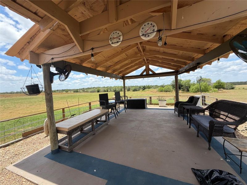 An inviting covered patio offers panoramic views of the verdant landscape, perfect for outdoor relaxation.