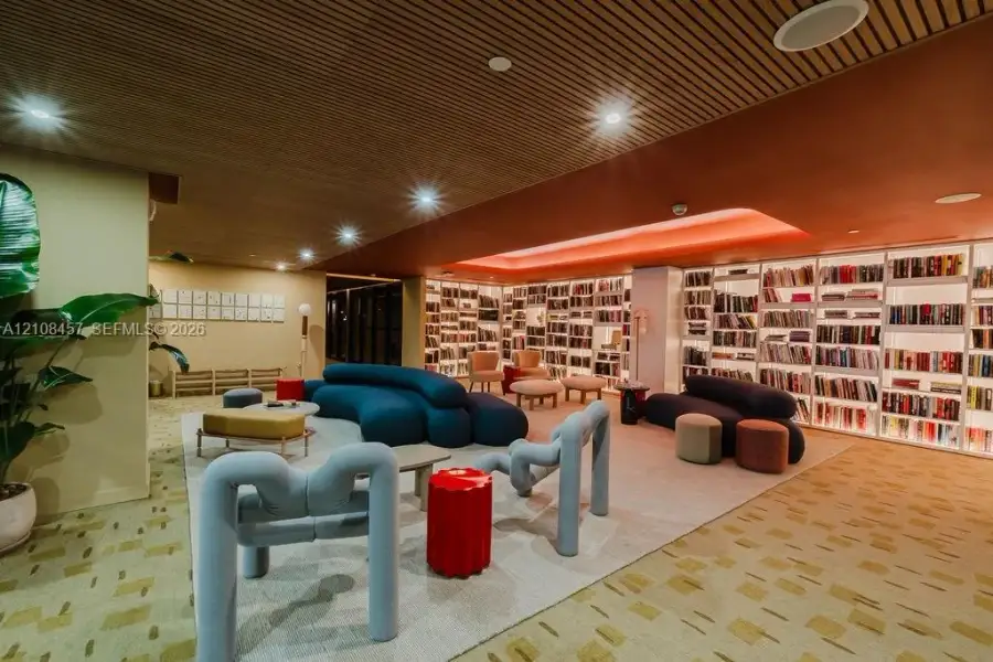 Slatted wood-plank ceiling featuring recessed lighting, expansive wall-to-wall built-in shelving, and integrated cove lighting Slatted wood-plank ceiling featuring recessed lighting, expansive wall-to-wall built-in shelving, and integrated cove lighting