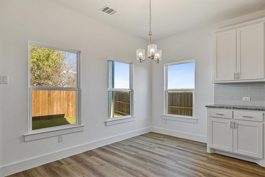 dining area featuring a chandelier and light wood-type flooring dining area featuring a chandelier and light wood-type flooring