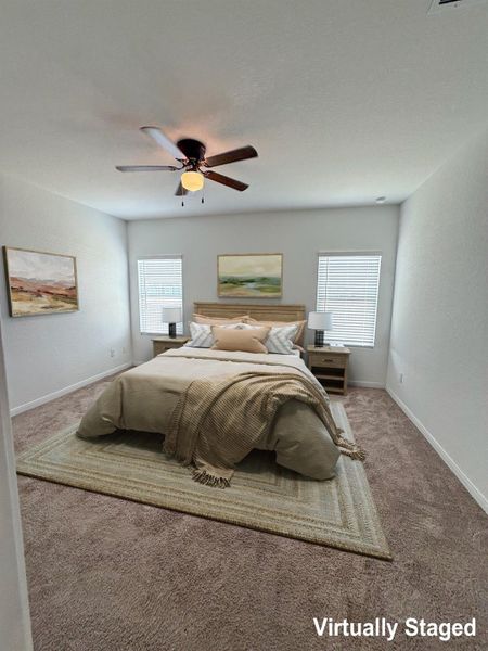 A well-lit bedroom features plush carpeting and a modern ceiling fan for ultimate comfort.