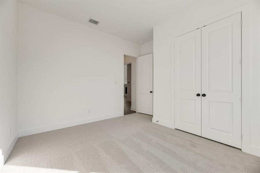 Unfurnished bedroom with carpet floors and baseboards