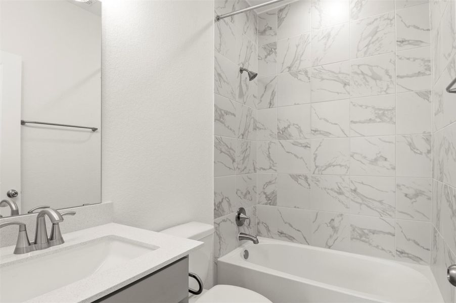 Bathroom featuring toilet, shower / tub combination, and vanity