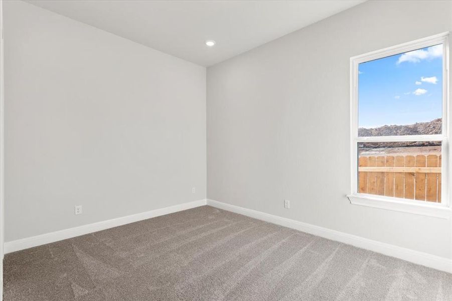 Spare room featuring dark colored carpet and recessed lighting