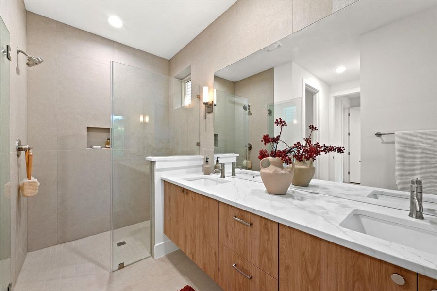 A well-appointed primary bathroom featuring a spacious walk-in shower and elegant double vanity. A well-appointed primary bathroom featuring a spacious walk-in shower and elegant double vanity.