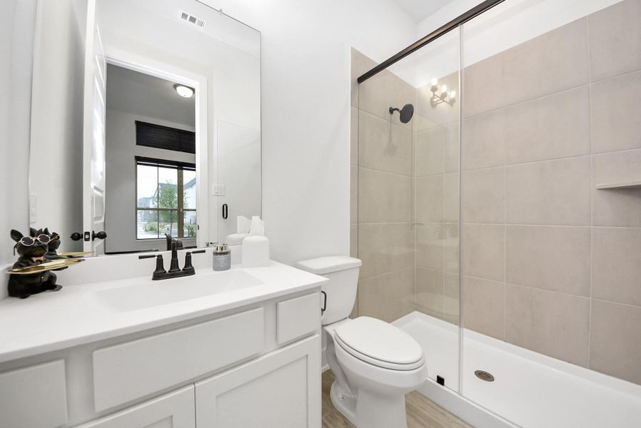 Private ensuite bathroom for Bedroom 2 featuring a sleek walk-in shower and modern finishes.