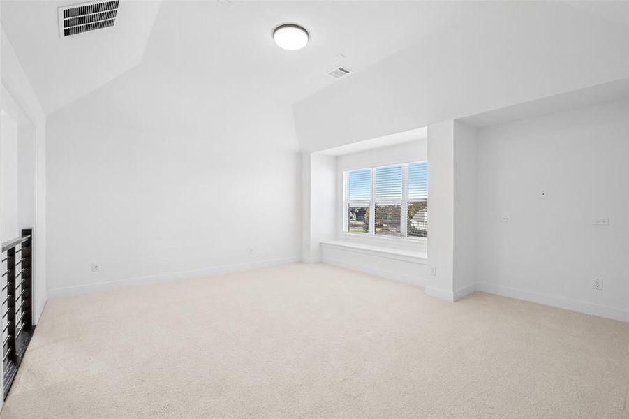 Additional living space with light colored carpet and vaulted ceiling Additional living space with light colored carpet and vaulted ceiling