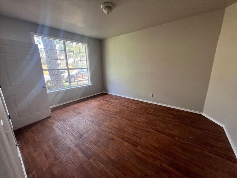 Unfurnished room with dark wood-style flooring and baseboards Unfurnished room with dark wood-style flooring and baseboards