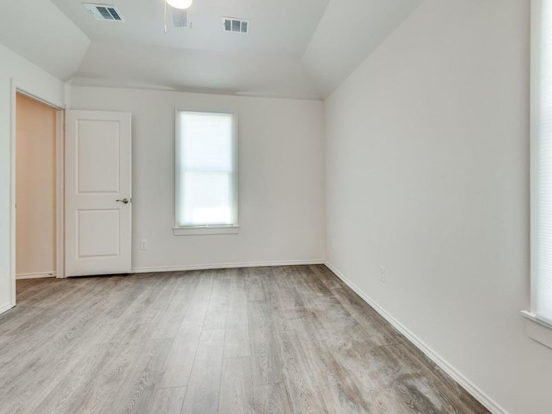 Unfurnished room featuring vaulted ceiling and hardwood / wood-style floors