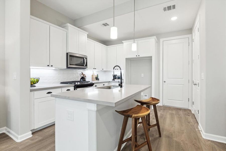 Outfitted with a Whirlpool gas range, dishwasher, and microwave, this kitchen seamlessly blends style with modern convenience—ready to inspire your next culinary creation.