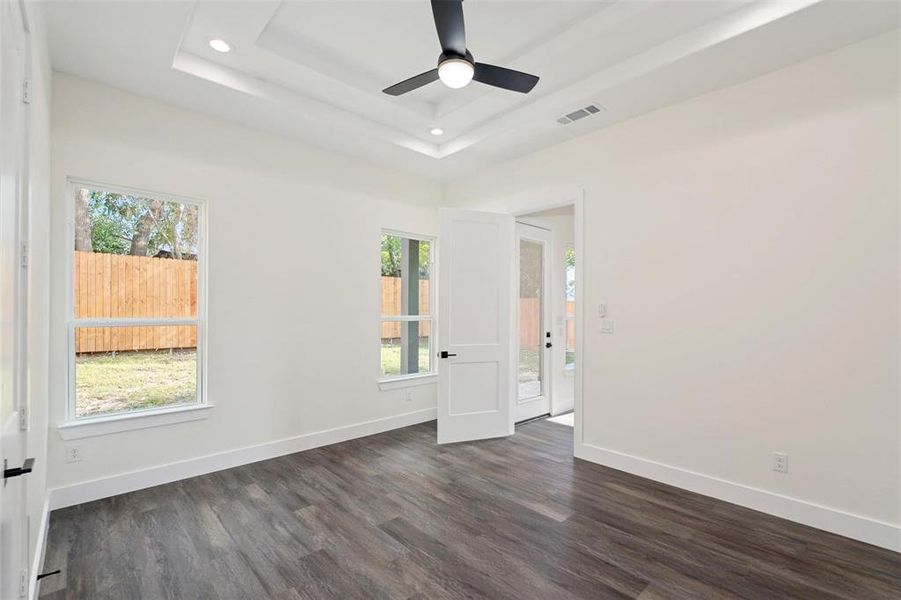 Spare room featuring plenty of natural light, dark wood-style floors, ceiling fan, and recessed lighting