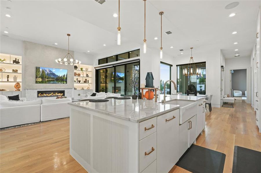 Kitchen featuring a chandelier, white cabinetry, open floor plan, a fireplace, and recessed lighting Kitchen featuring a chandelier, white cabinetry, open floor plan, a fireplace, and recessed lighting