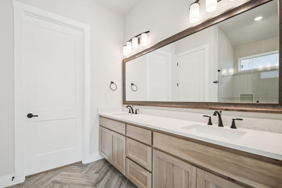 Bathroom with double vanity, an enclosed shower, and recessed lighting