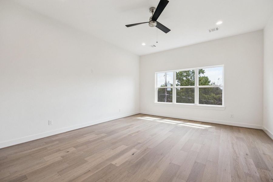 Spacious primary bedroom overlooking the back of the home offers plentiful space for large scale furniture as well as a seating area. Spacious primary bedroom overlooking the back of the home offers plentiful space for large scale furniture as well as a seating area.