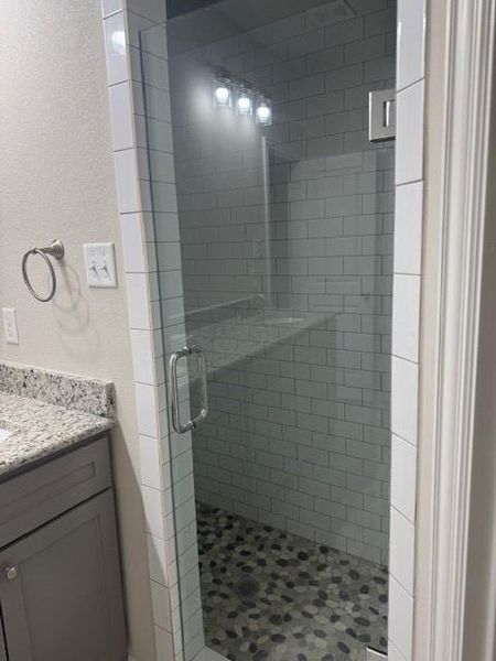 Bathroom with vanity and a shower with door