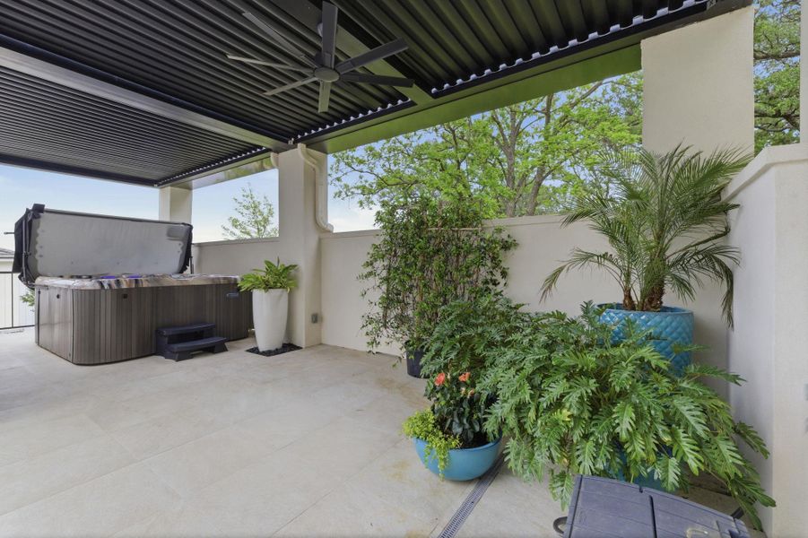 Fenced backyard featuring ceiling fan, a hot tub, and a pergola
