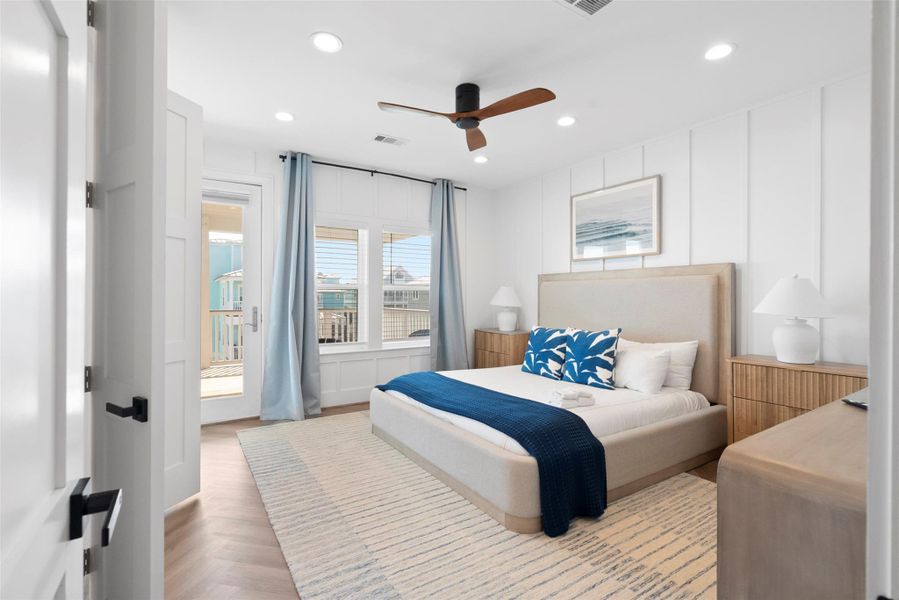Your peaceful retreat with room to breathe. This spacious primary suite features a plush queen- or king-sized bed with a foamed headboard, layered pillows, and blue-leaf throw pillows for a soft coastal touch. A large area rug grounds the space, while powder blue curtains frame the windows. Step right out to the balcony for fresh air and golden-hour views—comfort and connection, all in one. Your peaceful retreat with room to breathe. This spacious primary suite features a plush queen- or king-sized bed with a foamed headboard, layered pillows, and blue-leaf throw pillows for a soft coastal touch. A large area rug grounds the space, while powder blue curtains frame the windows. Step right out to the balcony for fresh air and golden-hour views—comfort and connection, all in one.