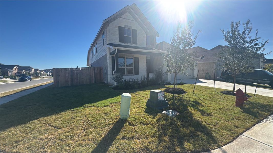 Traditional home with driveway, a residential view, a garage, and brick siding