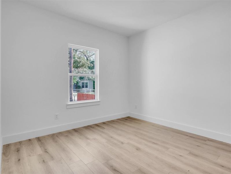 Empty room featuring baseboards and light wood-style floors Empty room featuring baseboards and light wood-style floors