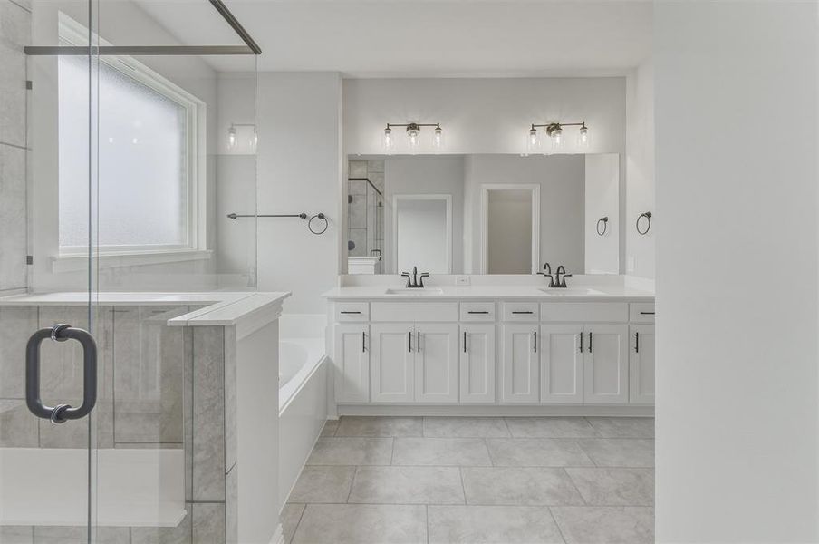 Spacious bathroom featuring a dual vanity with white cabinetry, a large mirror, and contemporary light fixtures