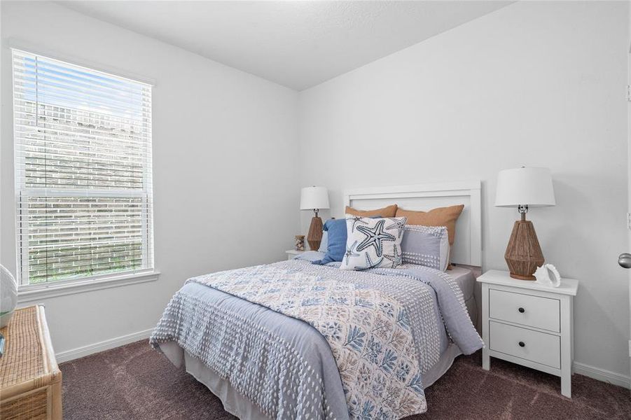 Secondary bedroom features plush carpet, neutral paint, lighting, large window with privacy blinds and ample sized closet space.