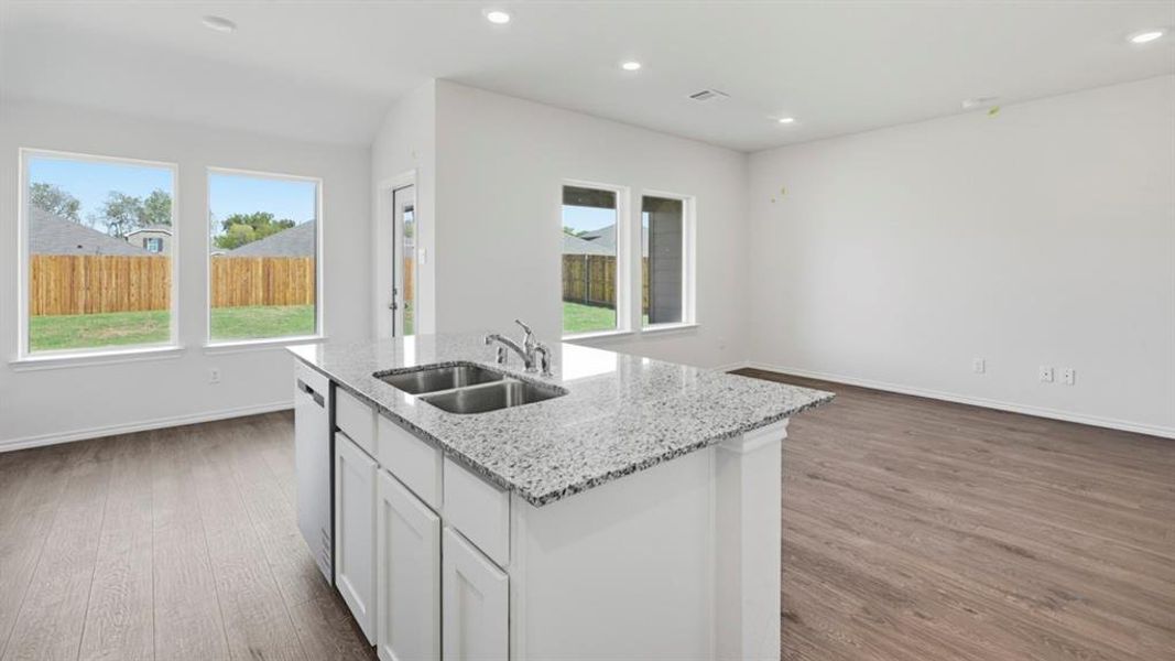 Kitchen featuring white cabinets, light stone counters, dark wood finished floors, recessed lighting, and healthy amount of natural light Kitchen featuring white cabinets, light stone counters, dark wood finished floors, recessed lighting, and healthy amount of natural light