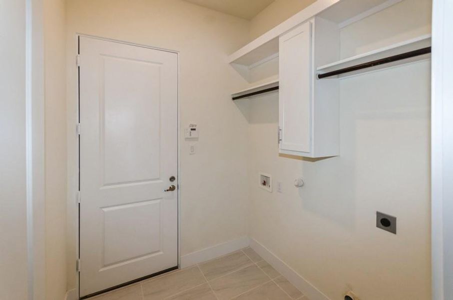 Laundry area with washer hookup, hookup for a gas dryer, light tile patterned flooring, and electric dryer hookup