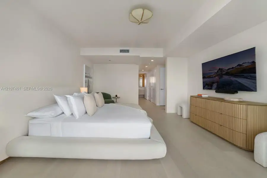Spacious room featuring light-toned wood-finish flooring, recessed ceiling lighting, a sculpted semi-flush mount fixture, and smooth wall finishes Spacious room featuring light-toned wood-finish flooring, recessed ceiling lighting, a sculpted semi-flush mount fixture, and smooth wall finishes