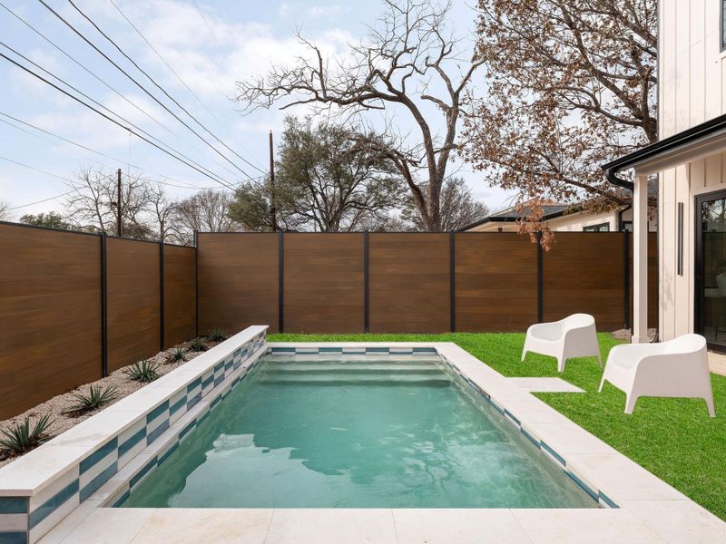 View of pool featuring a fenced backyard and patio surround
