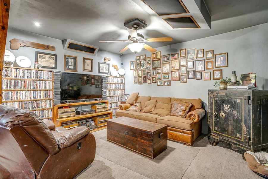 Carpeted living room with a ceiling fan Carpeted living room with a ceiling fan
